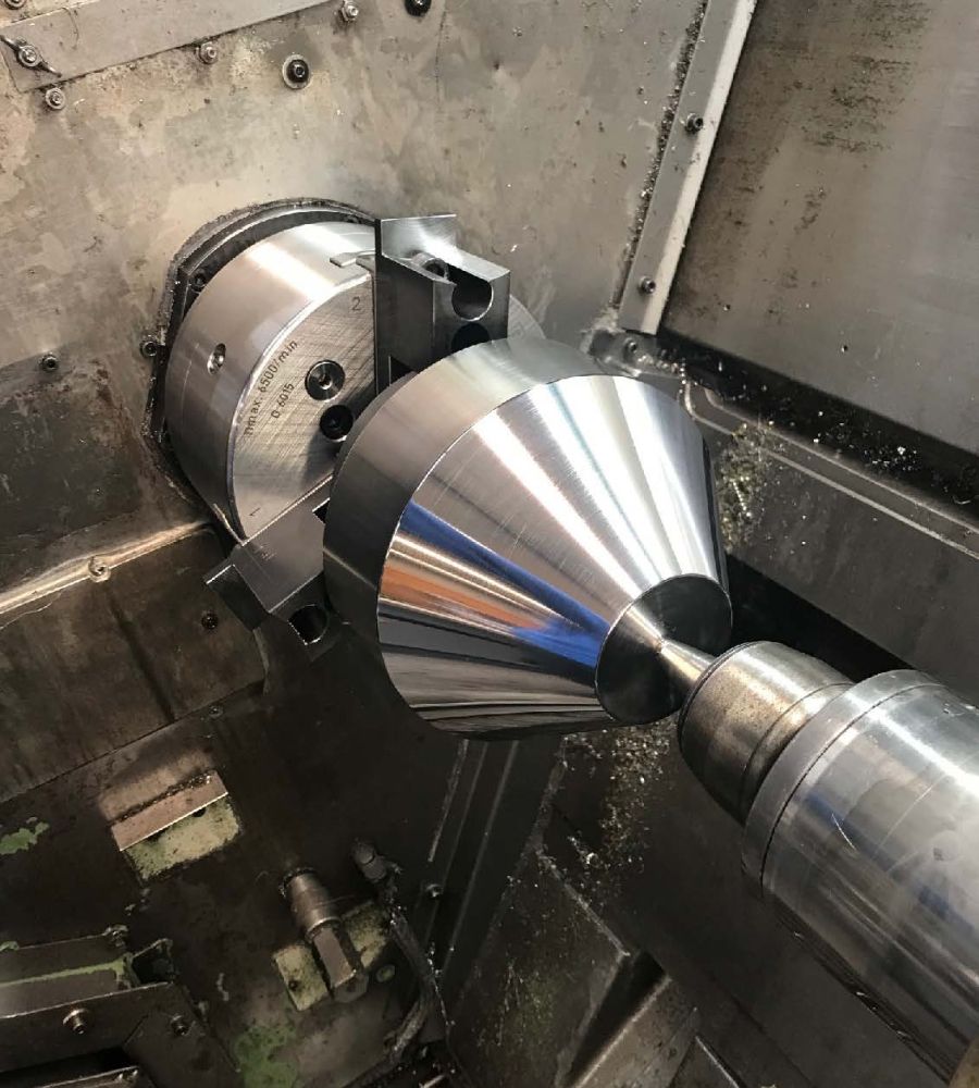 Eine glänzende Metallbearbeitungsmaschine in Aktion mit konischen Komponenten